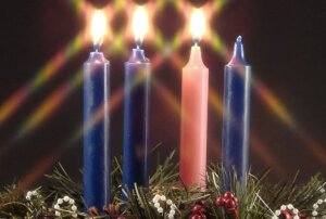 advent candle. 2 blue candles lit, 1 rose candle lit, 1 blue candle unlit