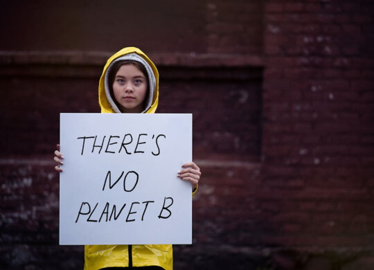 Teenager girl holding placard during global strike for climate c